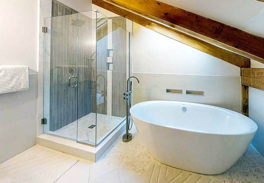 Bathroom with sloped ceiling, freestanding tub and shower with glass enclosure