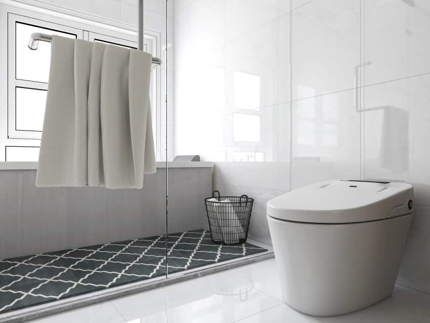 Bathroom with incinerating toilet, patterned rug, shower, glass door, and glossy tile floor and walls