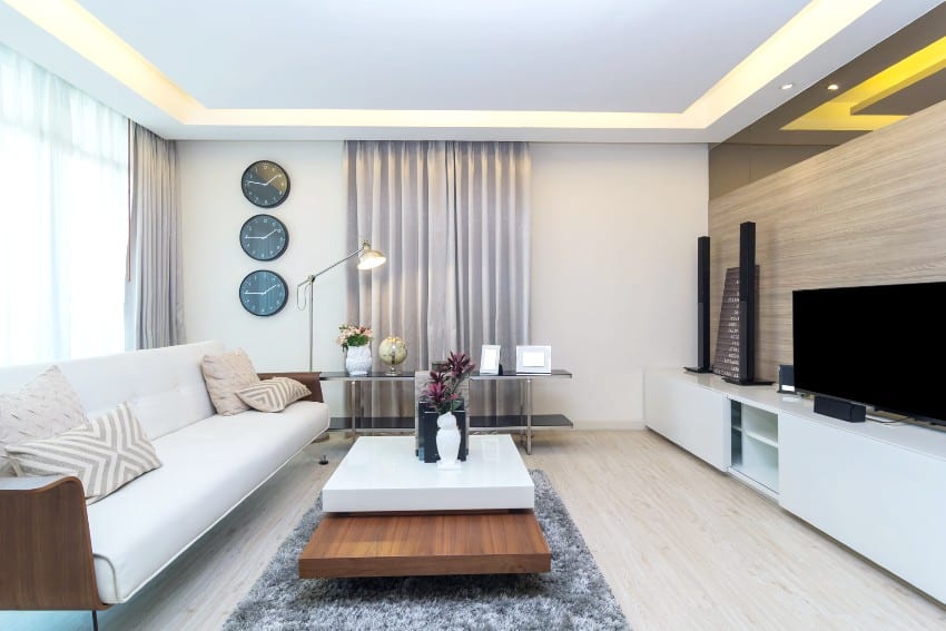 Furnished bright white room with ceiling tray lighting