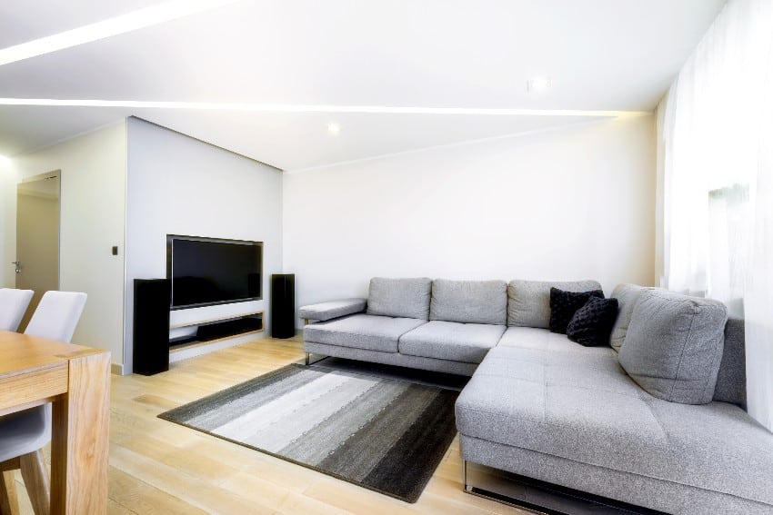 Modern, stylish room with big gray sofa and ceiling lighting